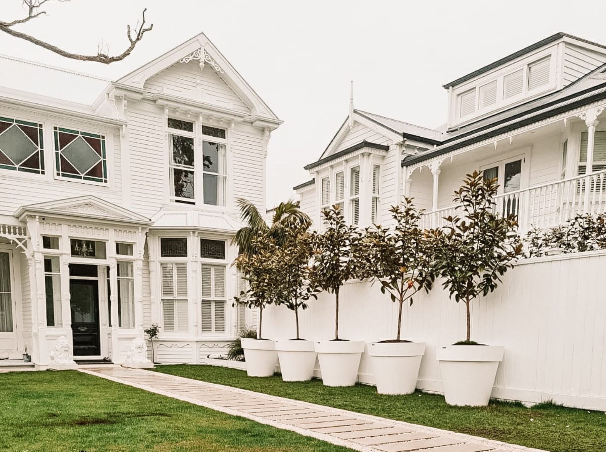 White colonial-style house with decorative planters in front