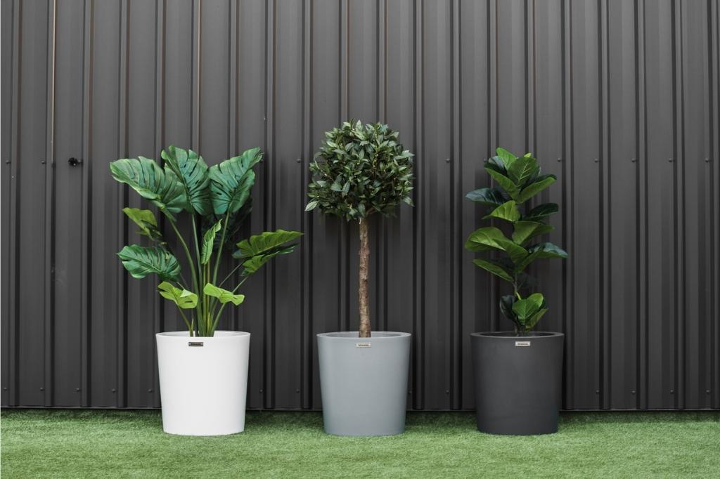 Modern style planter pots by Modscene in front of a black wall.