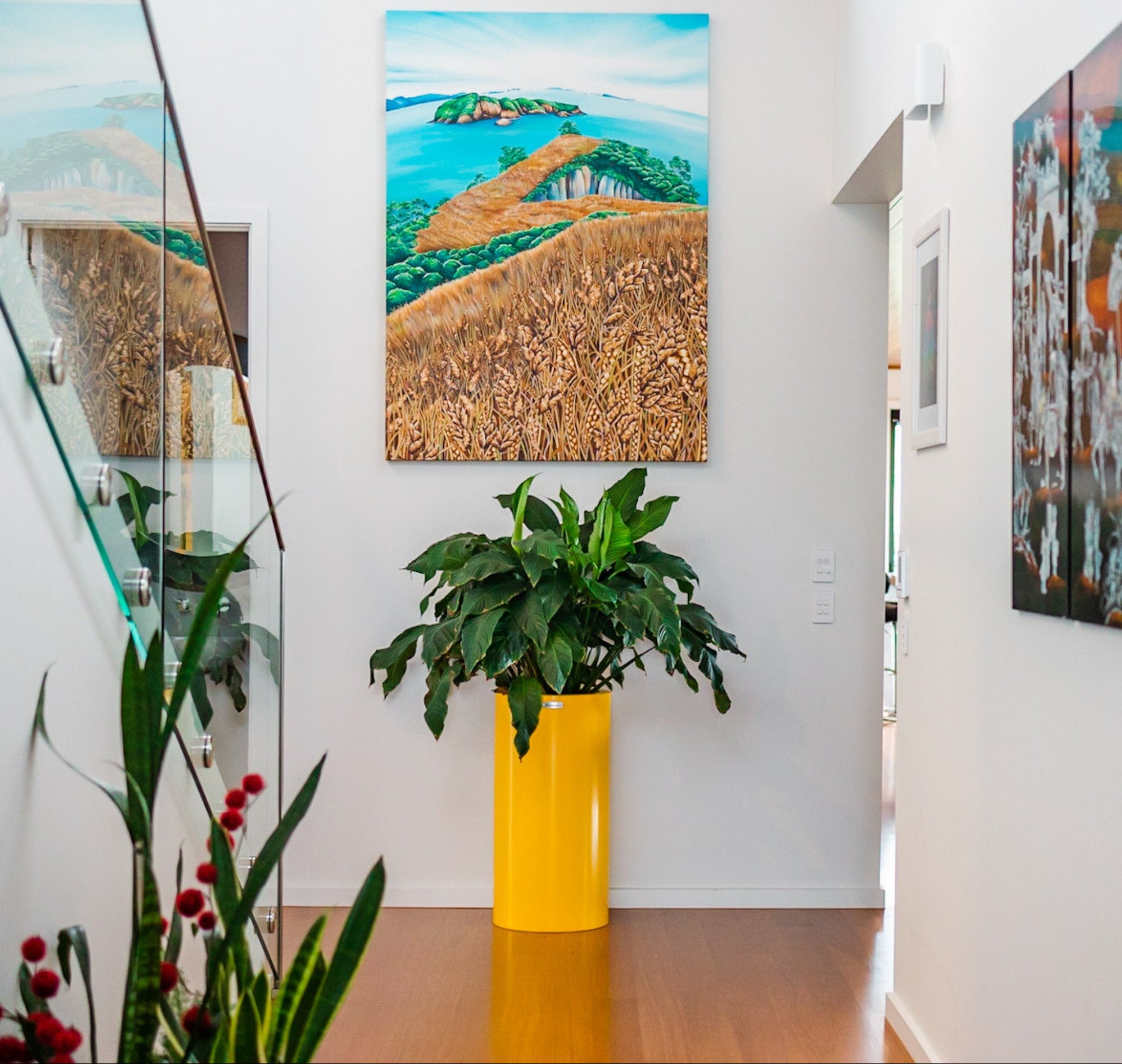 A yellow Modscene planter at the end of a hallway in a house.